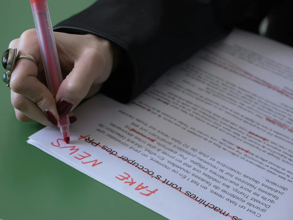 Una donna scrive su un foglio "Fake news"
